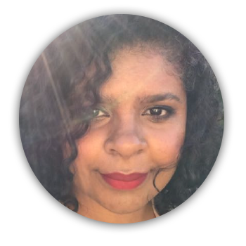 Imagem circular do rosto da Ana Carolina. Ana é uma mulher negra de pele clara. Está sorrindo num dia de sol. Ela usa batom vermelho e está sorrindo na foto.